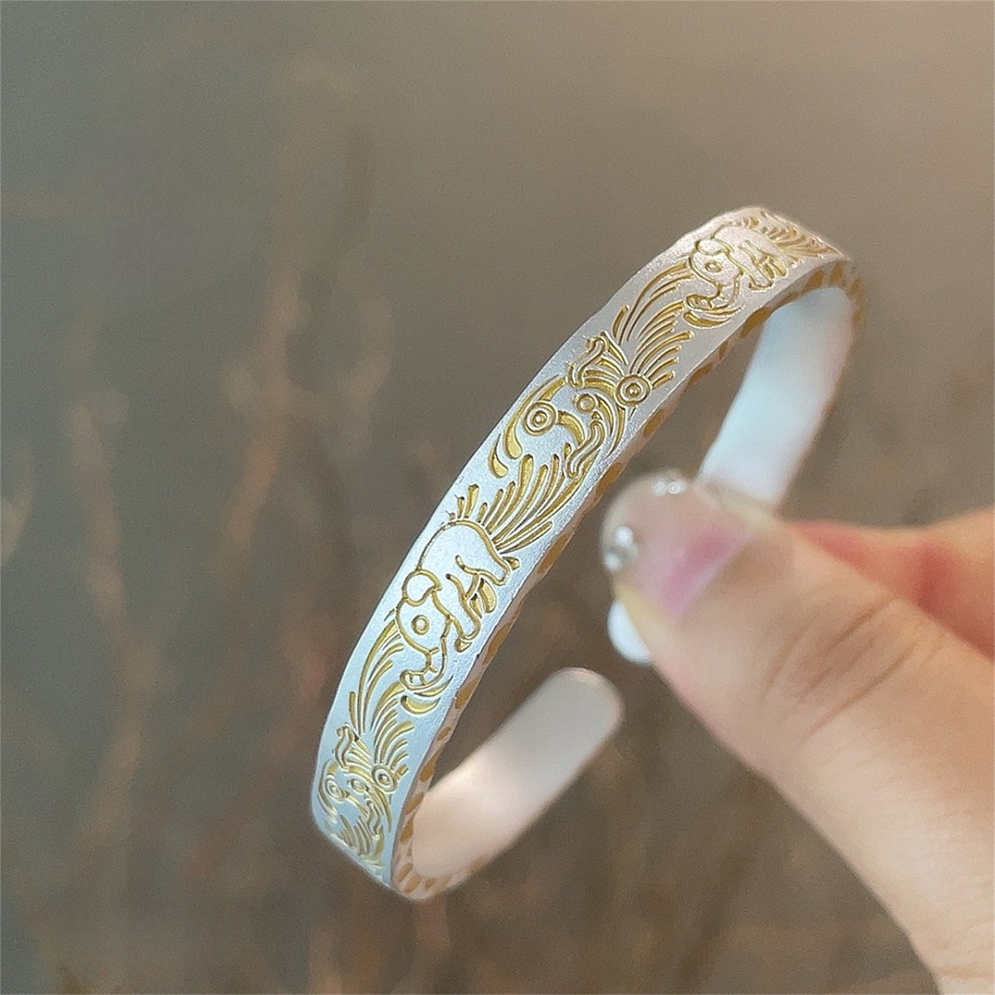 Solid bracelet with gold-painted lucky elephant and hammered pattern