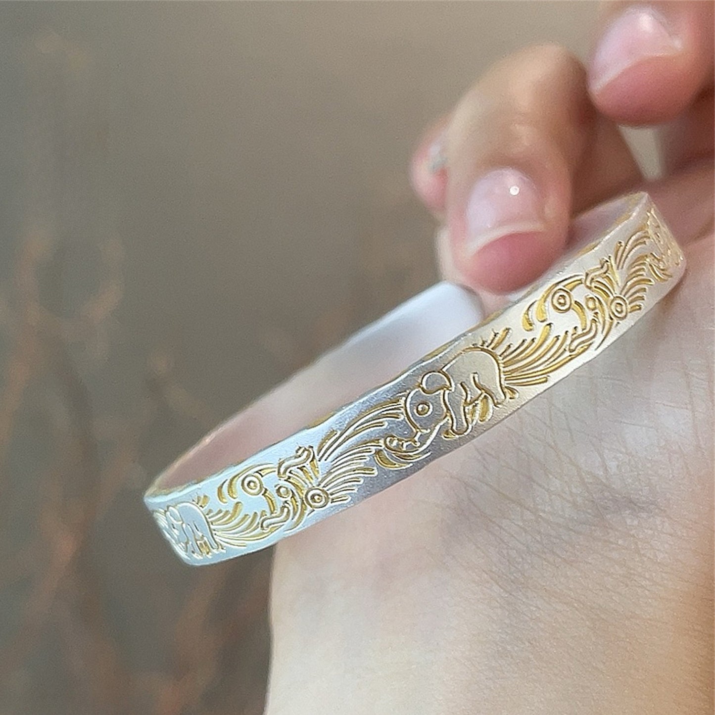 Solid bracelet with gold-painted lucky elephant and hammered pattern